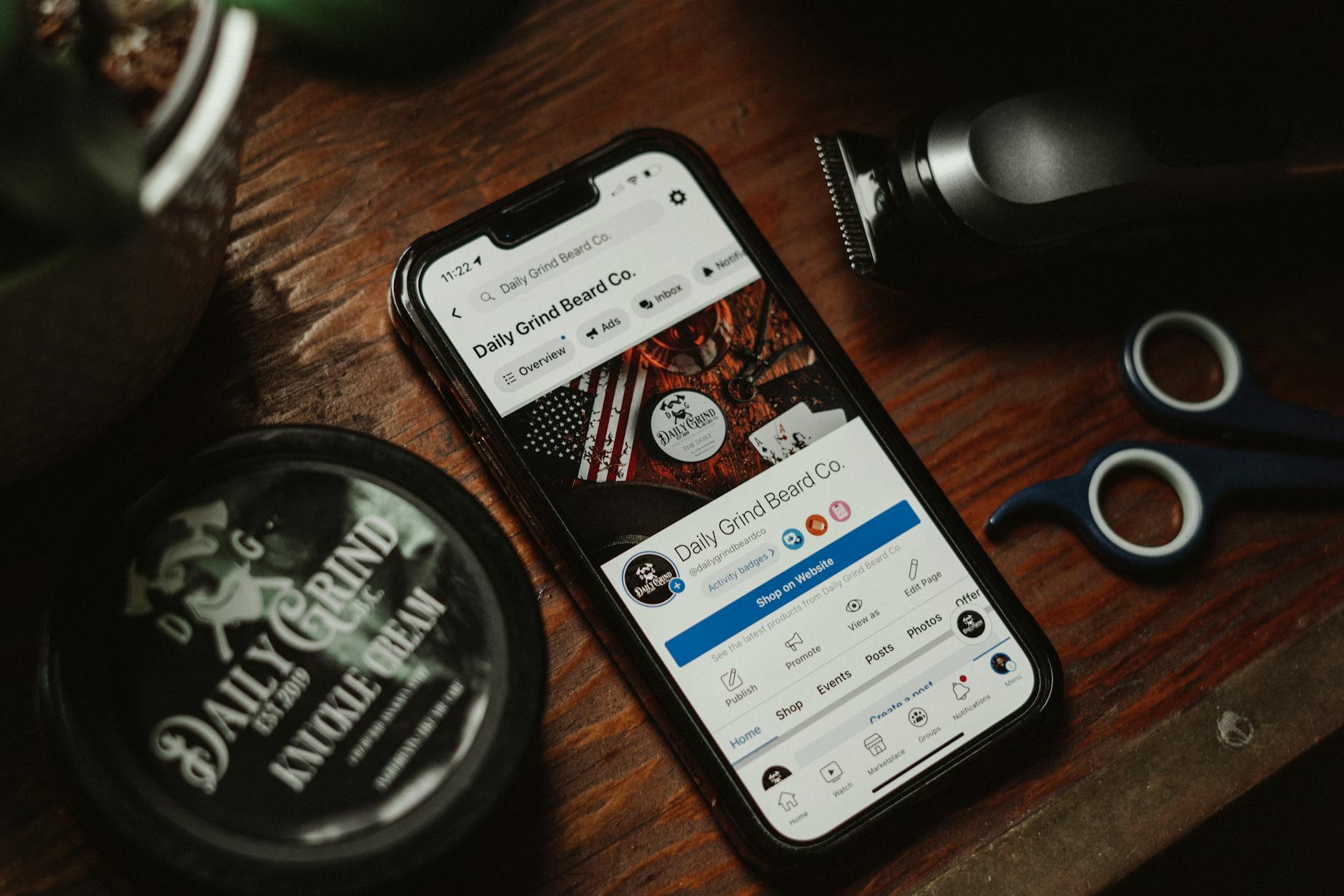 Akcesoria do pielęgnacji brody i smartfon na drewnianym blacie